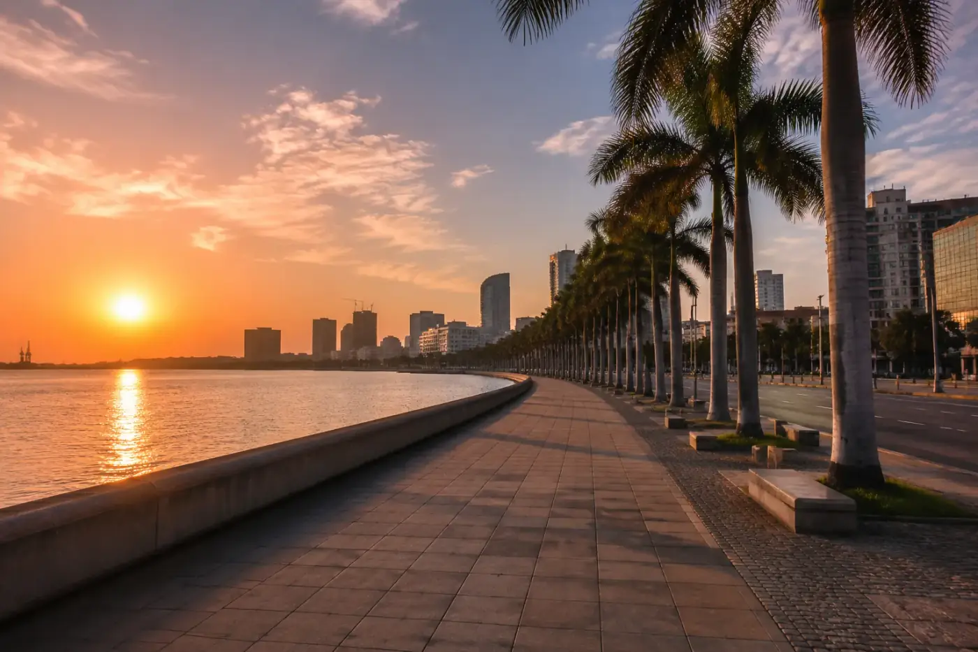 De Marginal-boulevard van Luanda bij zonsopgang met palmbomen langs het water