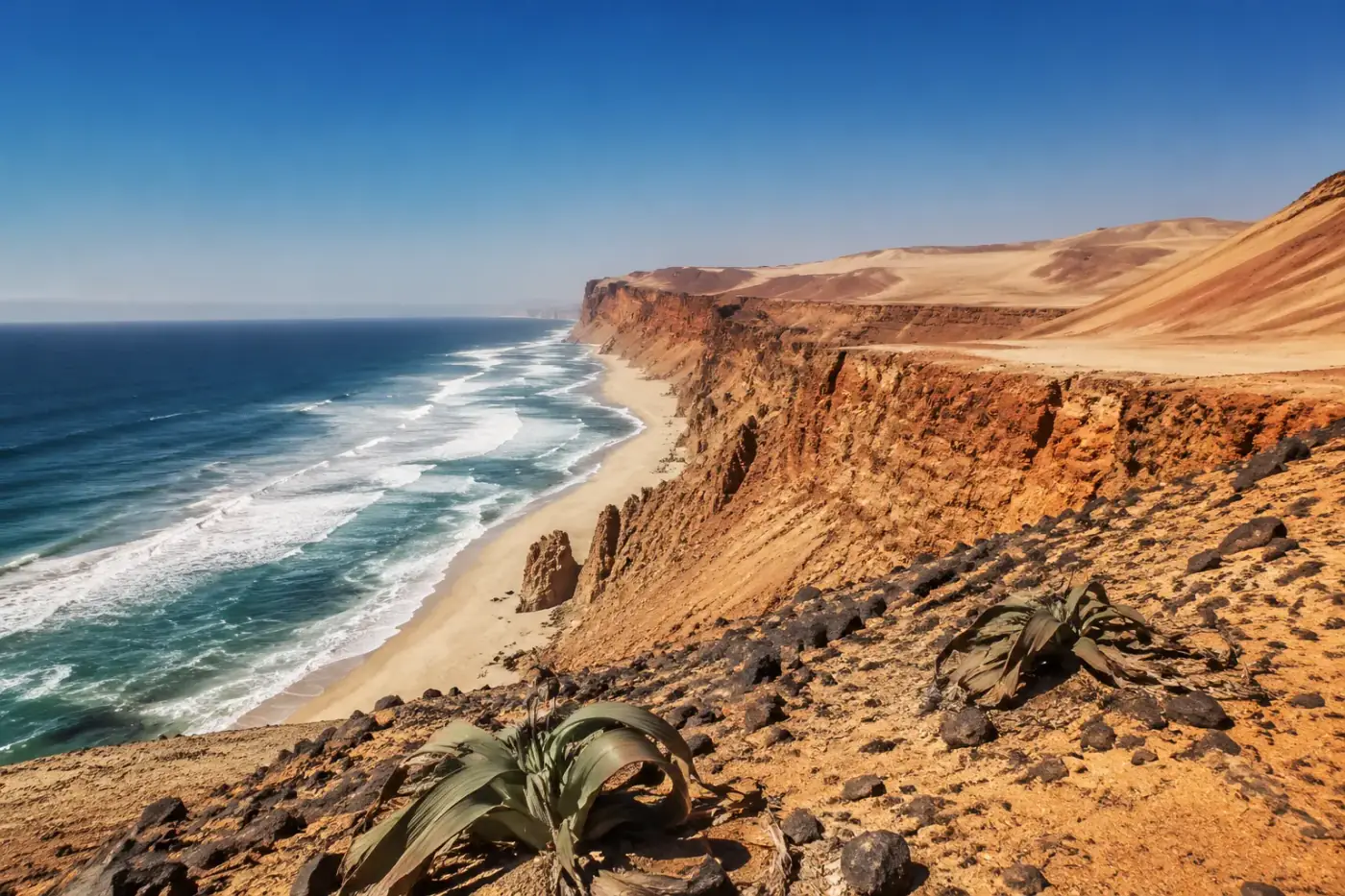 Namibe-woestijn met roodoranje kliffen die afdalen naar de Atlantische Oceaan